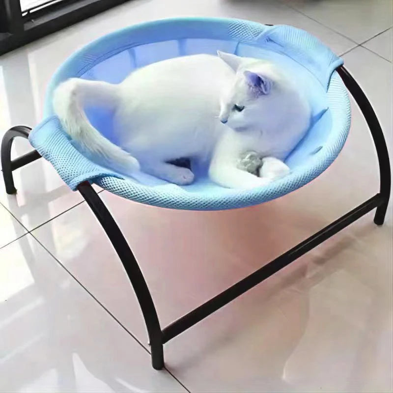 Cat resting in a blue mesh hammock bed on a low black metal stand